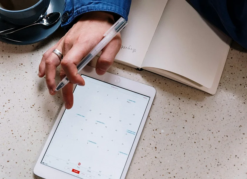 Eine Person mit Tablet und Kalender