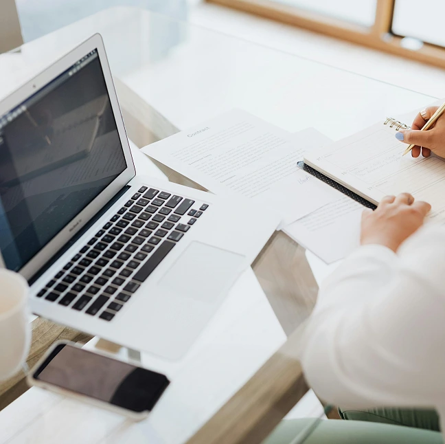 Eine Person an einem Schreibtisch mit Laptop