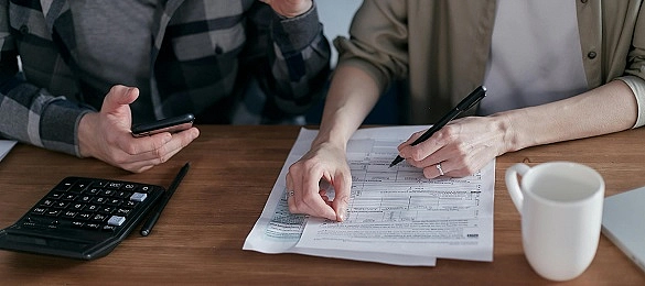 Zwei Personen füllen ein Formular aus