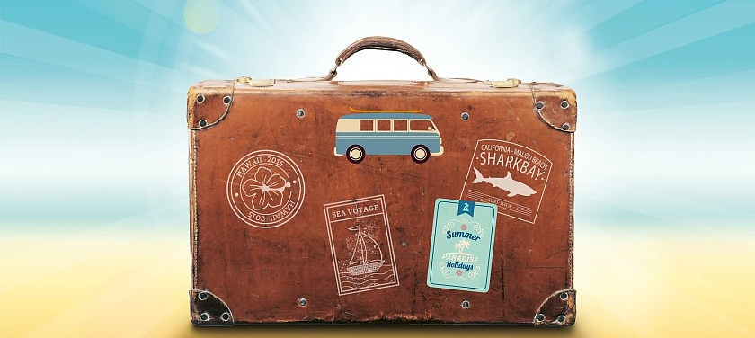 Das Bild zeigt einen Koffer mit Urlaubsaufklebern.