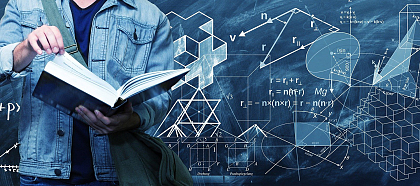 Das Bild zeigt einen jungen Mann, lesend in einem Buch. Im Hintergrund eine Tafel mit Formeln.