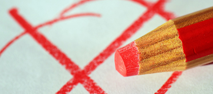 Das Bild zeigt einen roten Stift und ein Wahlkreuz.
